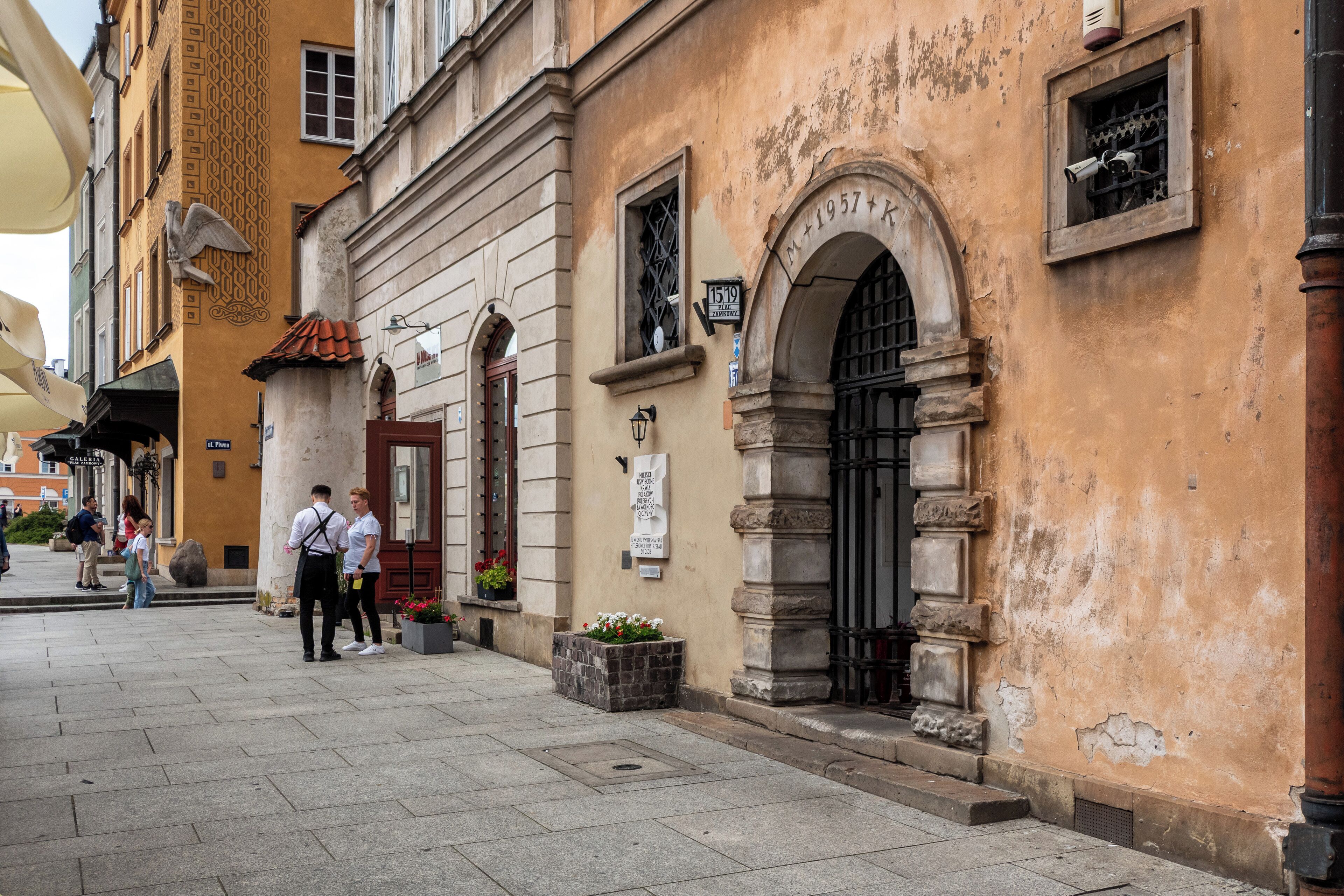 Ein historisches Gebäude mit einer Stein-Fassade, einem Bogenportal und einer Gedenktafel.