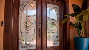 A wooden double door with decorative glass panels and a keyhole.