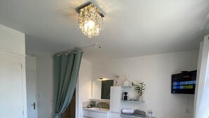 Une chambre d’hôtel comprenant un lit, un bureau, une chaise, une télévision et une salle de bain.