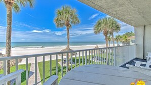 A balcony with a view of the beach, palm trees, and a clear sky. - Sea Oats 106: 3  BR, 2  BA Condominium in Redington Shores, Sleeps 8 (Redington Shores)