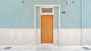 A door with a number plate, a peephole, and a small window above it. - The Urban Nest Comfort Suite by Wonderful Italy (Bari)