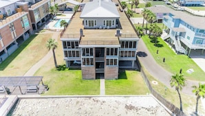 A large, multi-story building with a prominent central section and a smaller section to the left. - Gorgeous  Channelview Condo located on the ship channel in the heart of Port Ara (Port Aransas)