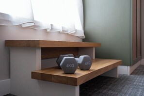 A wooden shelf with two 4KG dumbbells. - HUB Apartments – St. Georg (Hamburg)