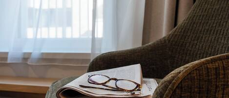 Una silla con un periódico y gafas encima.