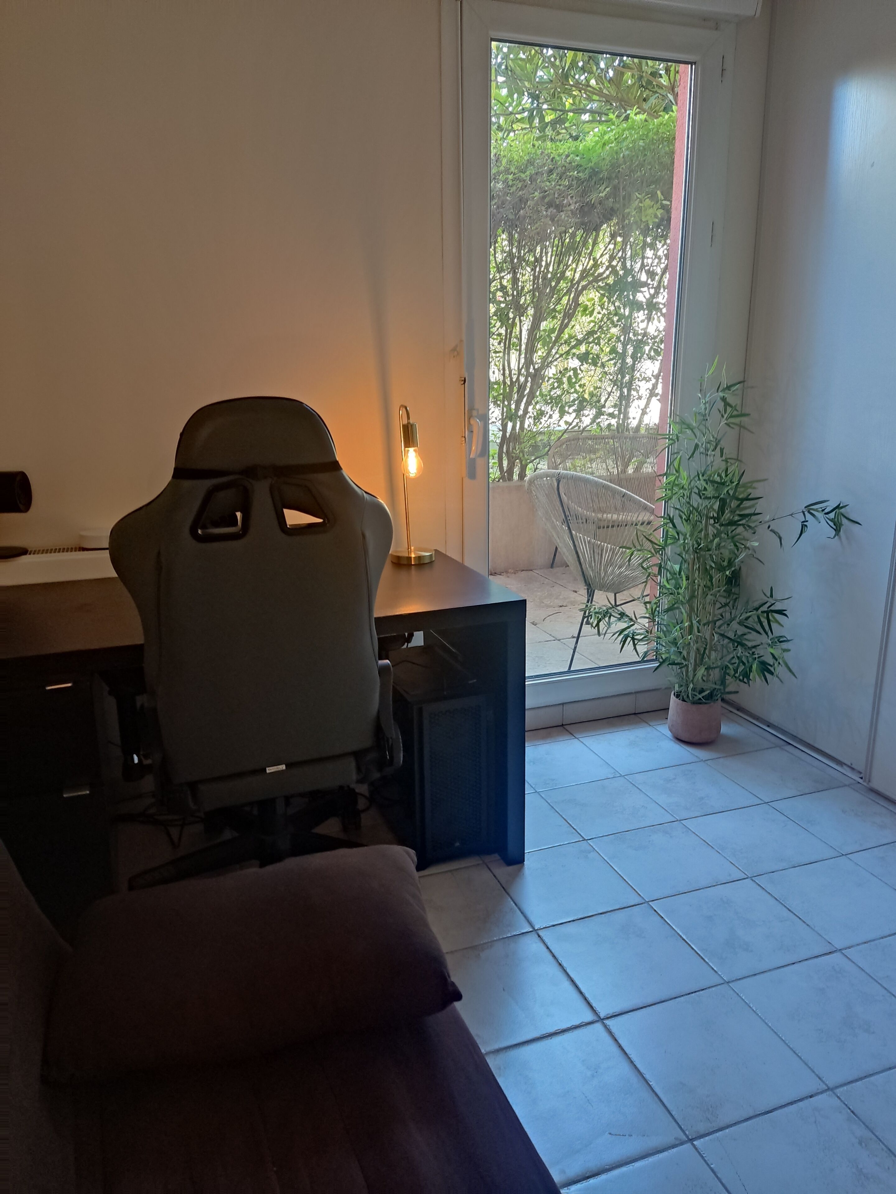 Un espacio de trabajo en casa con escritorio, silla y planta en maceta.