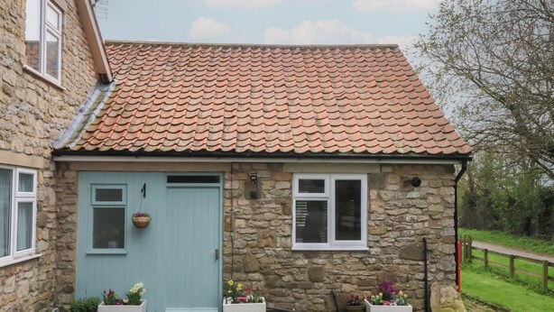 A stone house with a blue door, two windows, and a tiled roof. - Walnut Cottage (York)