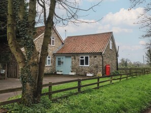 A stone house with a tiled roof, a blue door, and a red mailbox. - Walnut Cottage (York)