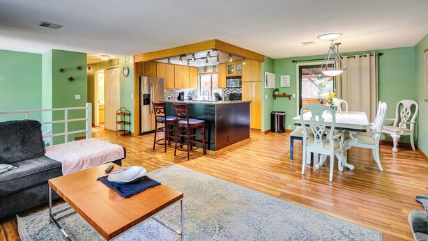 A spacious living room with a sofa, a coffee table, and a dining area with a table and chairs. - 3 Mi to U of O Pet-friendly Home w/ Covered Deck! (Eugene)