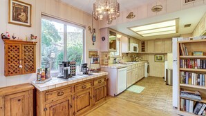 A kitchen with wooden cabinets, a coffee maker, and a bookshelf. - Walkable Location! Extended Escape in Sedona (Sedona)