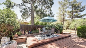 A wooden deck with a table and chairs, surrounded by trees and a wooden fence. - Walkable Location! Extended Escape in Sedona (Sedona)