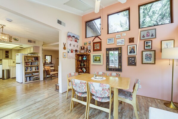 A cozy dining area with a wooden table and chairs, surrounded by bookshelves and framed pictures on the walls. - Walkable Location! Extended Escape in Sedona (Sedona)