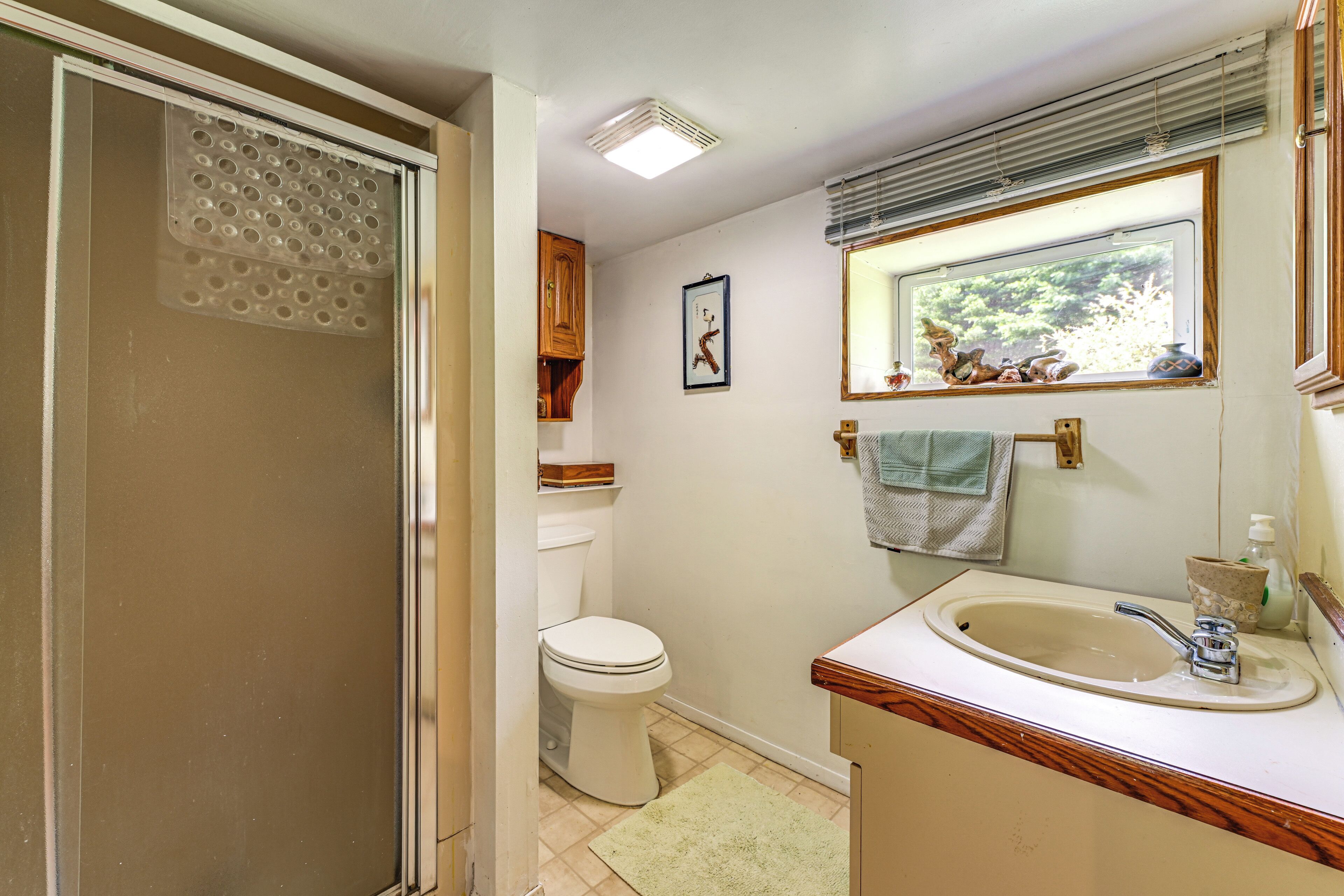 Een badkamer met toilet, wastafel en raam.