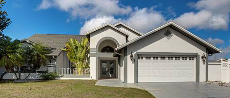 A modern two-story house with a garage, a front porch, and a well-maintained lawn.
