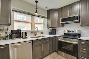 Una cocina moderna con electrodomésticos de acero inoxidable, lavavajillas integrado y una estación de café.