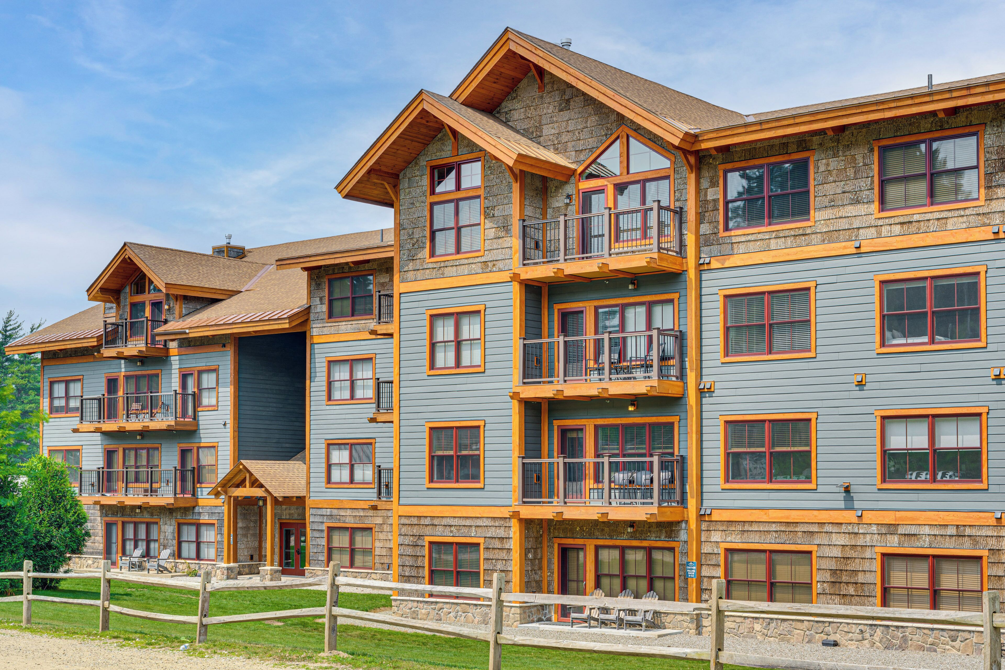 A multi-story hotel with balconies, a stone facade, and a wooden deck area.