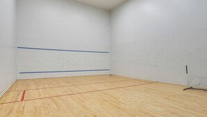 A squash court with wooden flooring, white walls, and blue lines marking the court. - Lake Access & Community Pool: Cozy Condo in Mound (Mound)