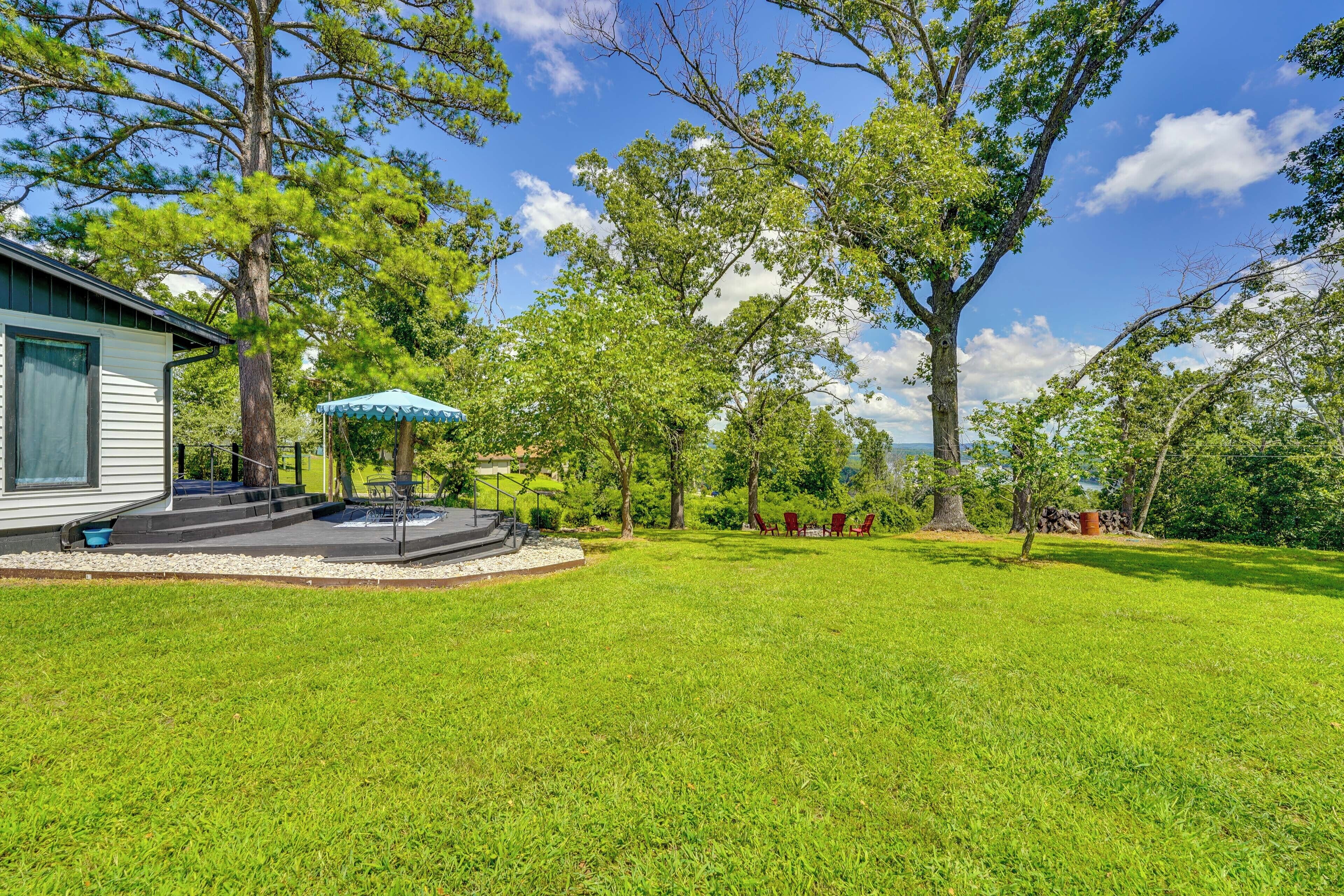 A well-maintained lawn with a patio area, outdoor seating, and a view of the surrounding landscape.