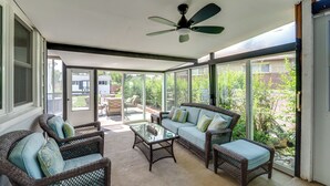 A sunroom with wicker furniture, a ceiling fan, and large windows offering a view of the backyard. - Walk to Frontier Days: Cheyenne Home w/ Patio! (Cheyenne)