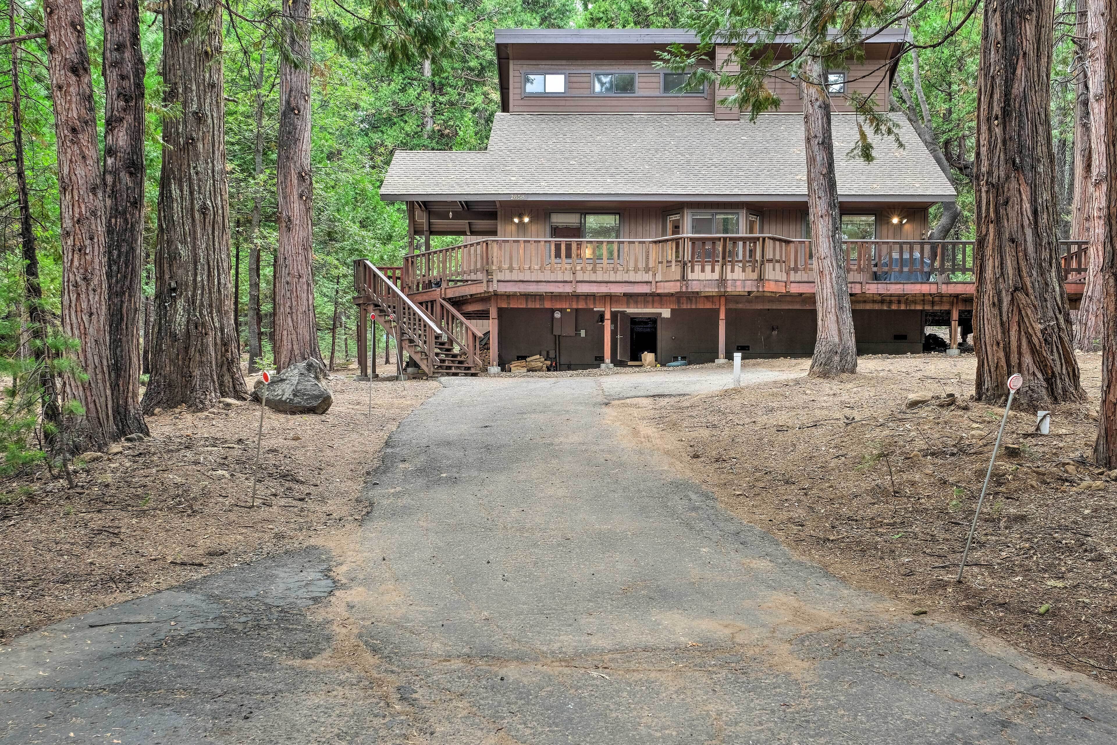 A cabin with a wooden exterior, a balcony, and a covered porch area.