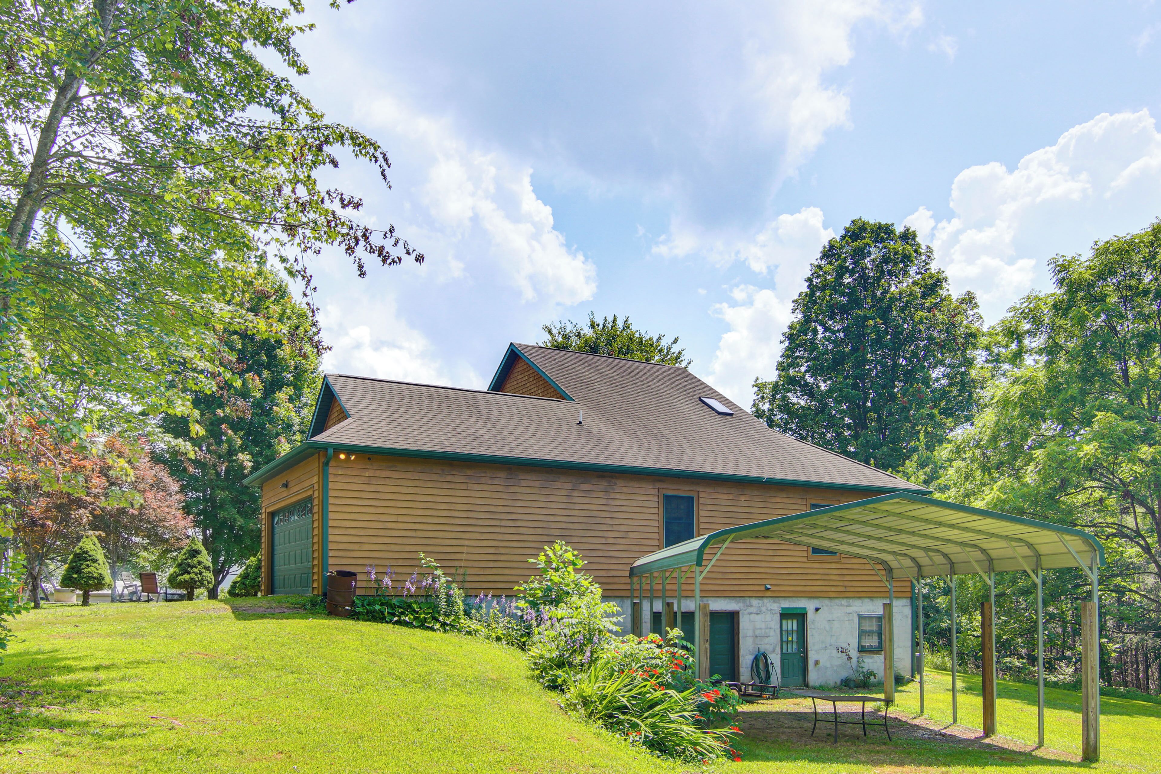 A two-story wooden house with a covered patio and a garage.