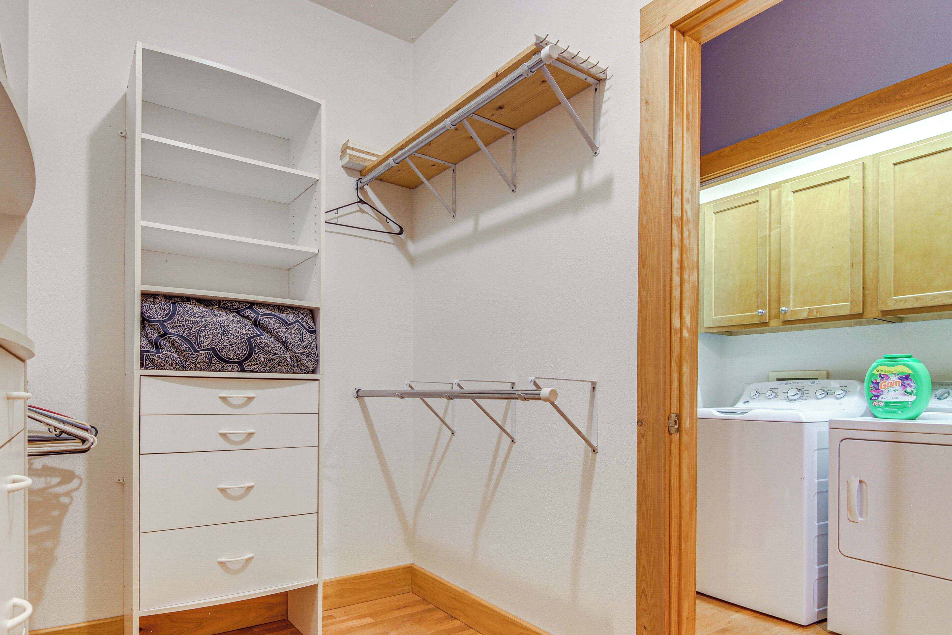 A laundry area with a drying rack, a washing machine, and a cabinet.