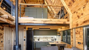 A modern log cabin interior with a loft bedroom, a kitchen, and a living area with a sofa and a coffee table. - A-home Villa Private Pool Relaxing Hottub Oasis (Heraklion)