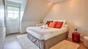 A bedroom with a bed, bedside table, lamp, and a window. - Le Riviera - Port Cergy | Modern & Cosy (Port-Cergy)