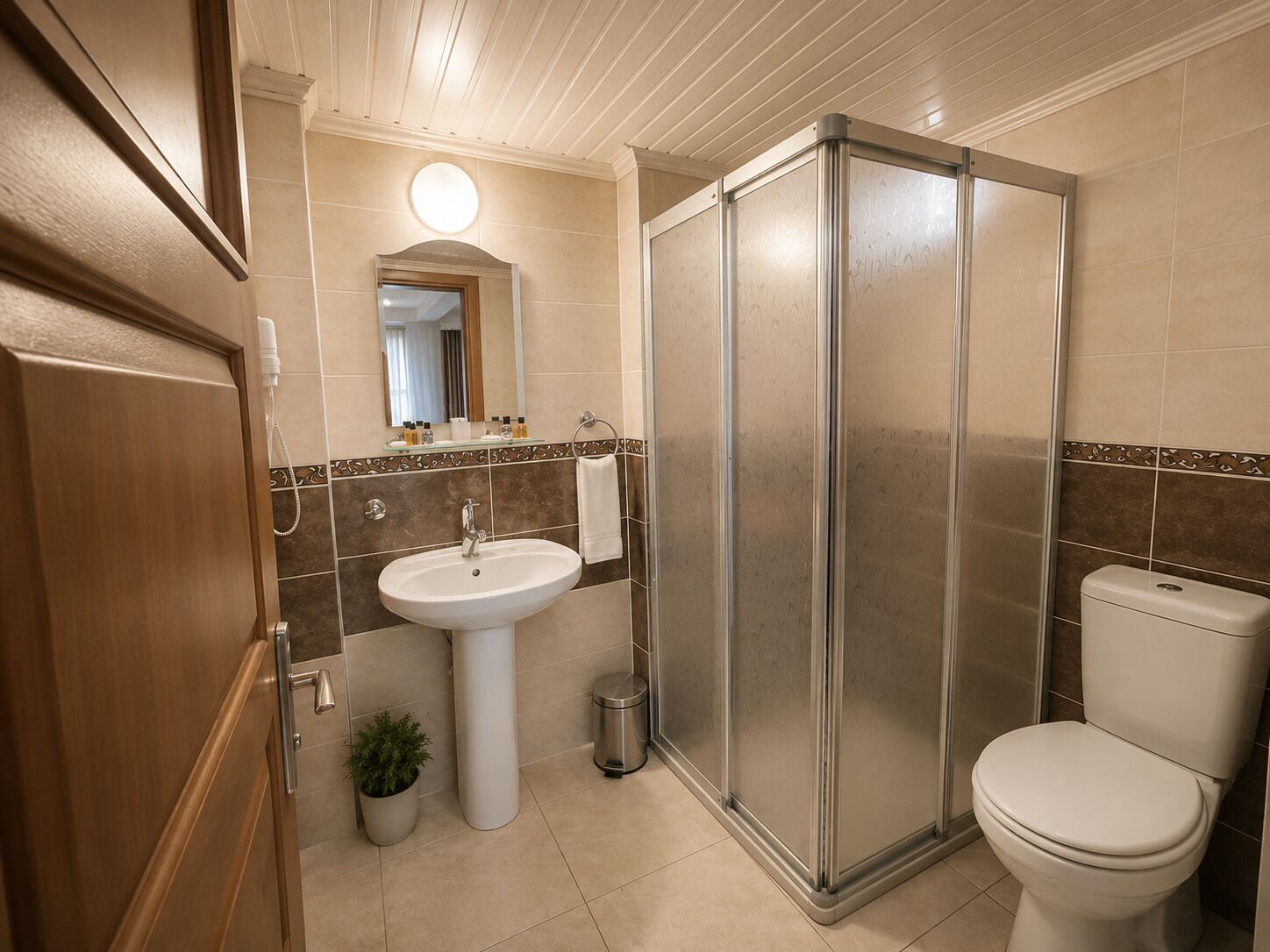 Un baño con lavamanos, inodoro y ducha.