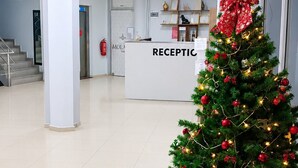A reception area with a Christmas tree, a reception desk, and a staircase.