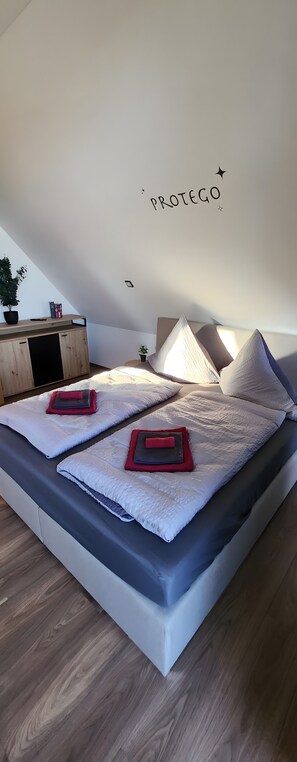 Una camera da letto con un letto, cuscini, un comodino e un soffitto decorato con un motivo a stelle.