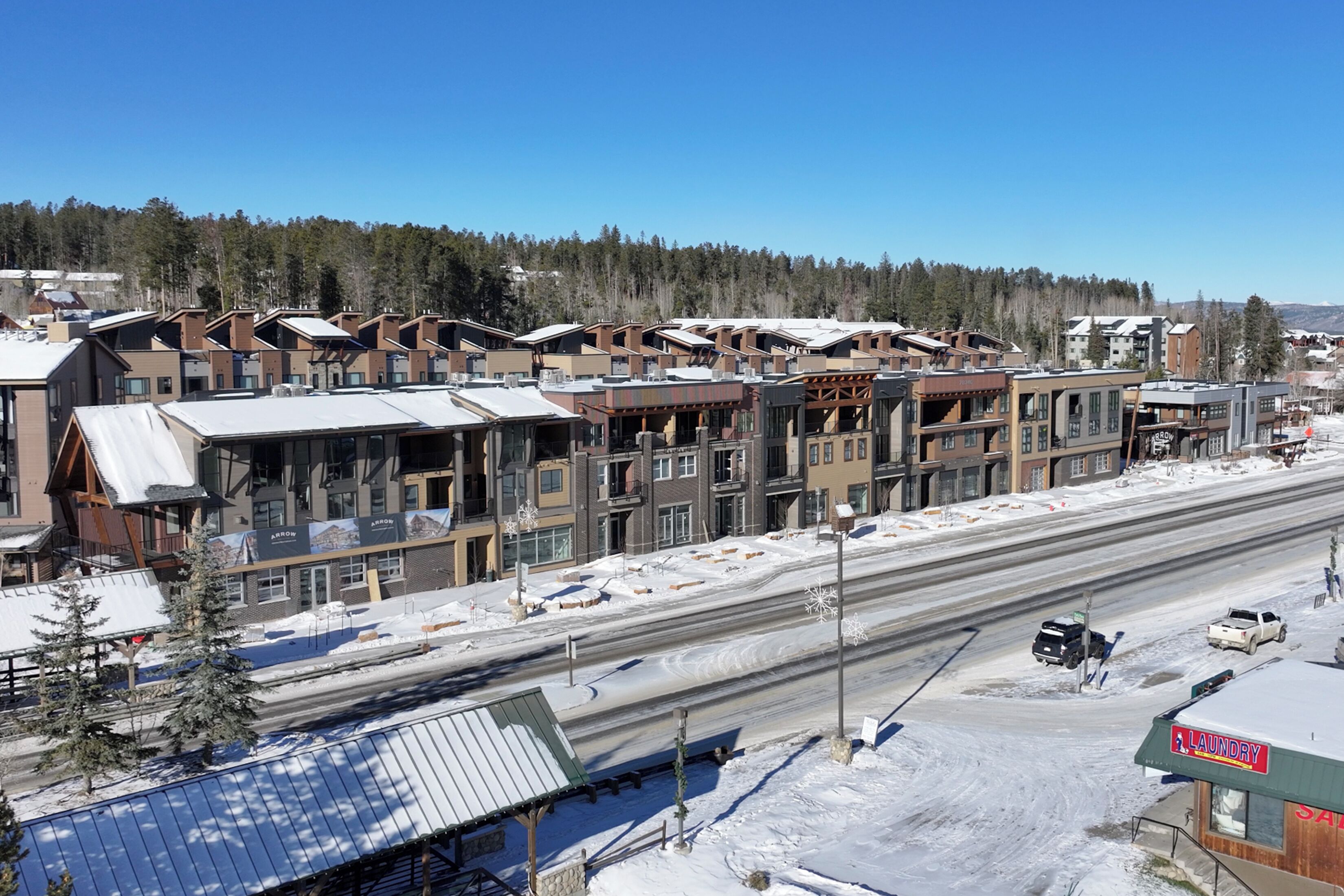 A multi-story building with a mix of commercial and residential units, featuring large windows and a flat roof.