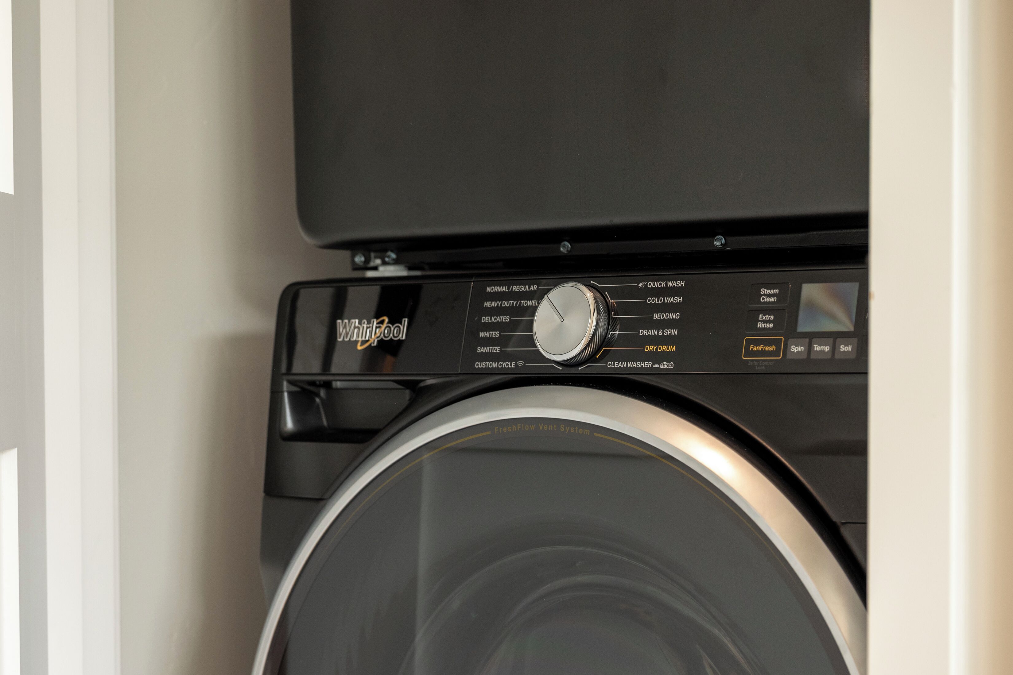 Vue de face d’un lave-linge Whirlpool, avec différents programmes de lavage et un panneau de commande.