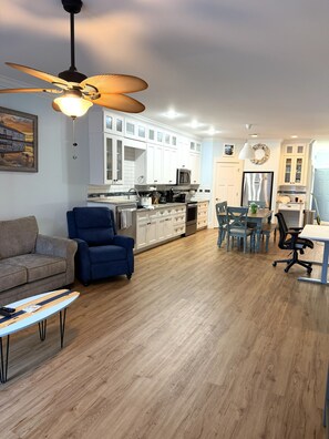 A modern living room with a sofa, a blue armchair, and a coffee table. - Sandy Dreams, 2-bedroom dog-friendly duplex in Garden City w/fenced yard (Murrells Inlet)