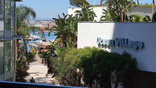 A view of Ocean Village with a clear sky, a marina with boats, and lush greenery. - One Bedroom Ocean Village Apt (Gibraltar)