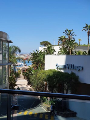 A view of Ocean Village with a clear sky, a marina with boats, and lush greenery. - One Bedroom Ocean Village Apt (Gibraltar)