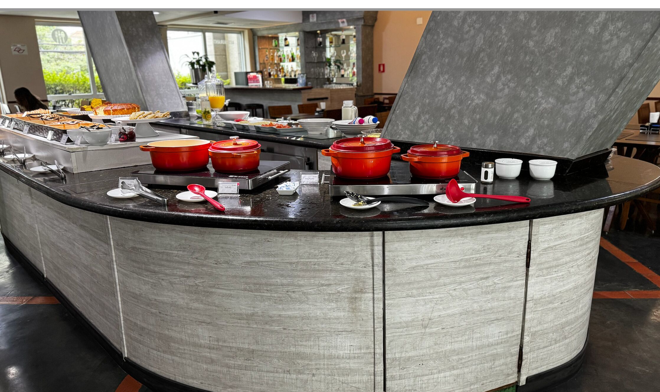 A buffet counter with various food items and cooking equipment.