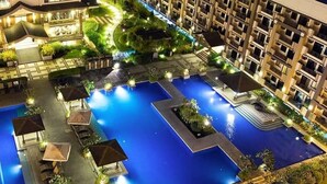 Un hôtel doté d’une grande piscine, de nombreux balcons et d’espaces extérieurs bien éclairés.