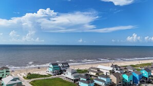 A coastal residential area with houses near the beach, a clear sky, and the ocean. - Casa de Tortuga: 4  BR, 3  BA House in Crystal Beach, Sleeps 12 (Bolivar Peninsula)