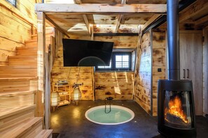 A wooden cabin interior with a fireplace, a small window, and a bench. - A-Home Villa, Private Pool & Jetted Tub Oasis (Nea Alikarnassos)