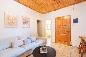 Un salon avec un canapé, une table basse et une porte en bois.
