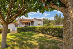 Il s’agit d’une propriété résidentielle comprenant une maison, une pelouse bien entretenue et un arbre au premier plan.