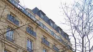 Ein mehrstöckiges Gebäude mit verzierten Balkonen und einem zentralen Eingang.