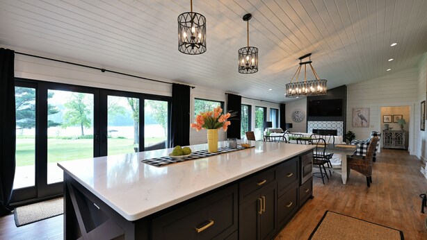 A spacious kitchen with a large island, dark cabinetry, and pendant lighting.