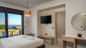 A bedroom with a bed, bedside tables, a TV, a mirror, and a view of the beach. - Terra Magna - Alba Villa (Rhodes)