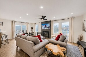 A modern living room with a sofa, a coffee table, a fireplace, and a television. - Bliss At Blue Church 441 2 Bedroom Condo (Park City)
