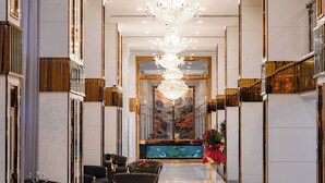 A hotel lobby with a long corridor, seating area, and a reception desk. - Golden Empire Suvarnabhumi Hotel (Bang Phli)