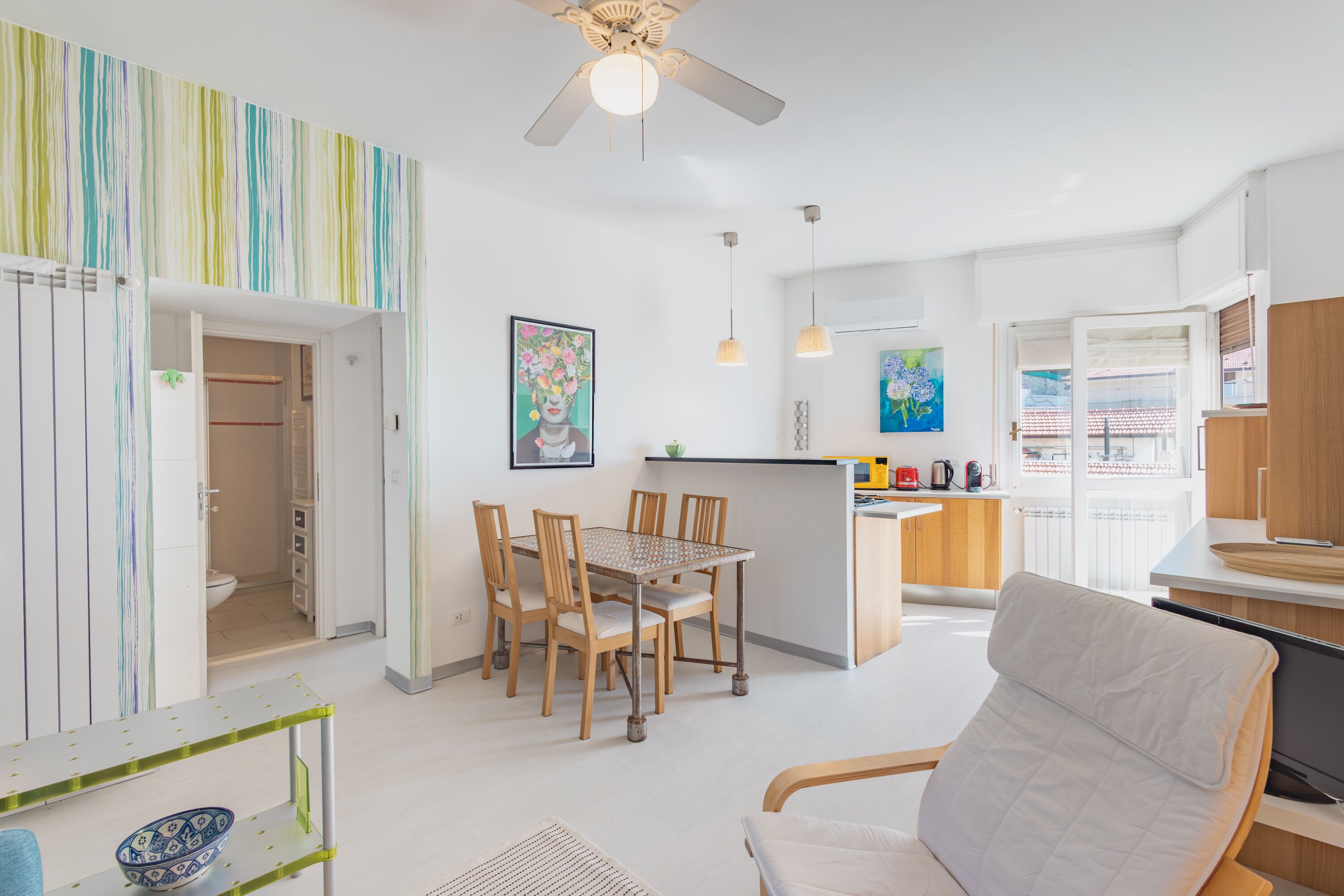 A modern apartment with a dining area, kitchen, and living room.