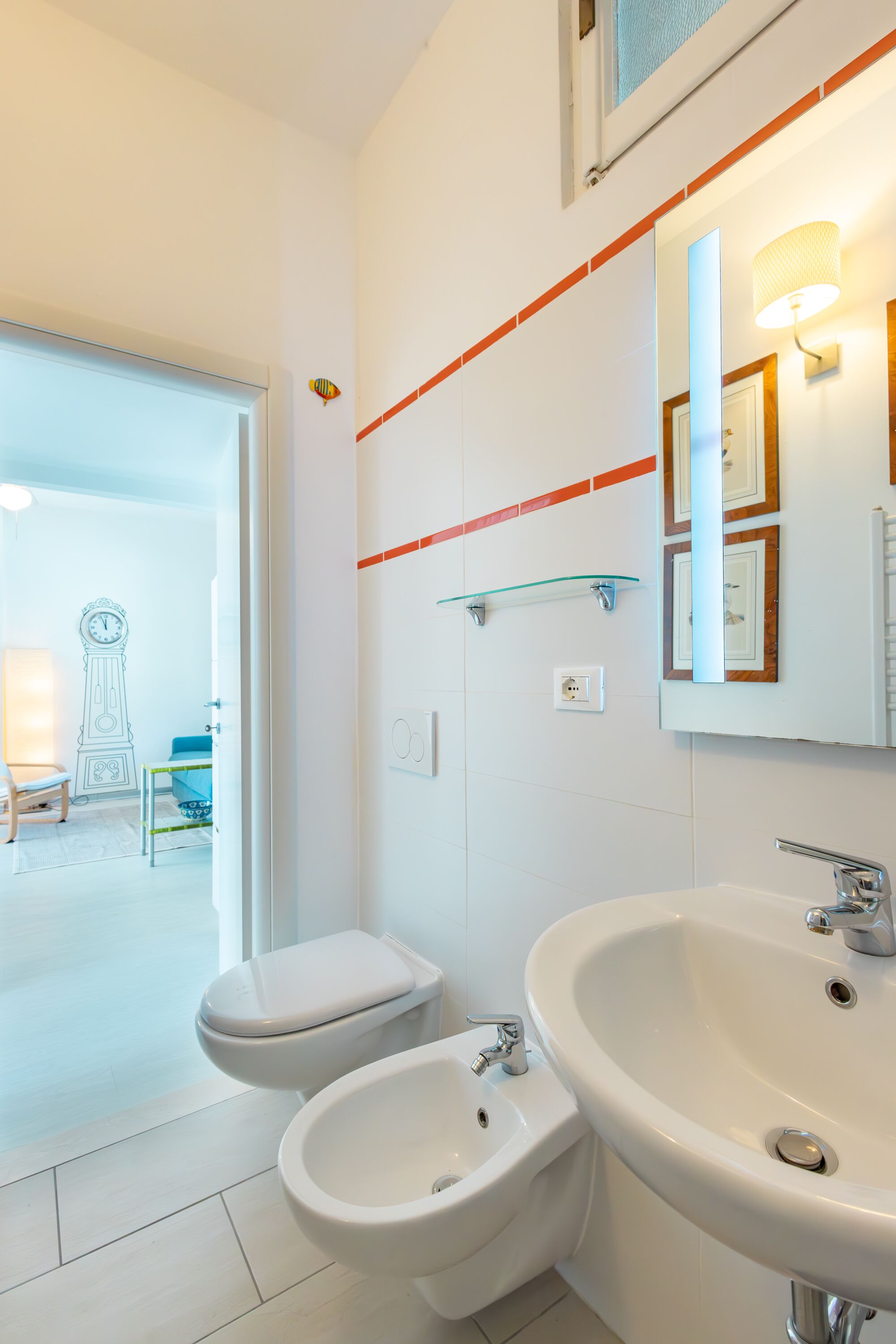 A modern bathroom with a toilet, bidet, and large sink.