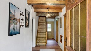 A wooden staircase leading to a room with a window, a door with a glass panel, and a wall-mounted picture frame. - Chalet 'Glosaleite Zillertal' with Mountain View, Private Terrace and Wi-Fi (Zellberg)