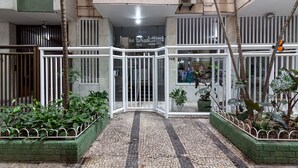 A building entrance with a tiled floor, metal gates, and potted plants. - Comfort in Copacabana, 9 minutes from the beach | CJ202 (Rio de Janeiro)